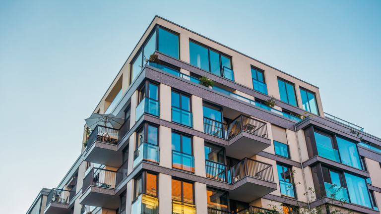 modern corner apartment complex with blue colored windows and light leaks