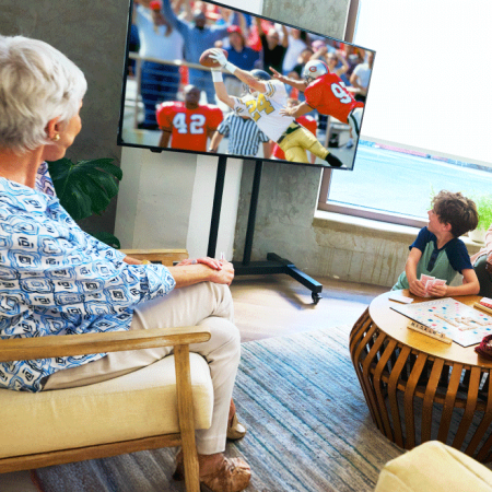 Senior watching TV with grandchild