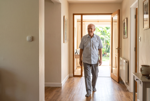 elderly man walking comfortably at senior living communitiy protected by fall detection system