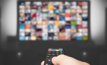 Video on demand, TV streaming, multimedia. Hand holding remote control