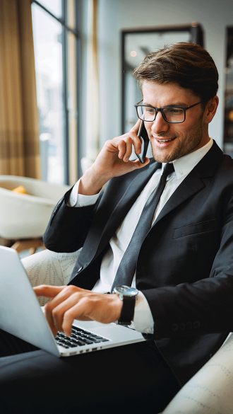 business-man-on-mobile-while-working-on-laptop-in-hotel