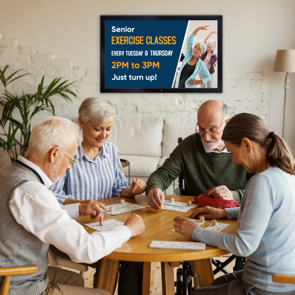 Seniors at a table with Digital Signage