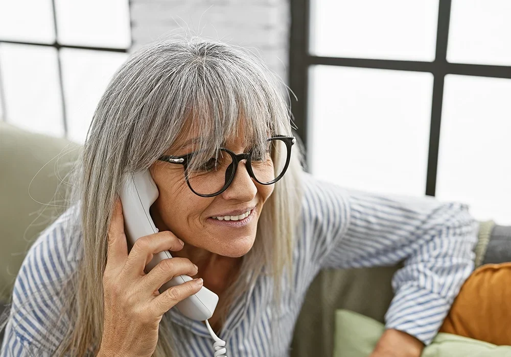 Older Woman Using Phone Voice System at Retirement Community