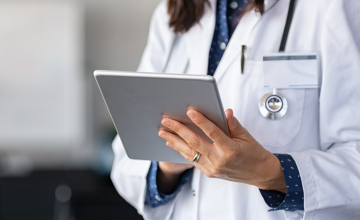 Doctor in Hospital Using Wi-Fi on Tablet