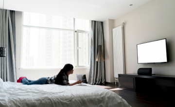 Woman Watching TV In Hotel