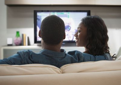 couple using directv programmed remote