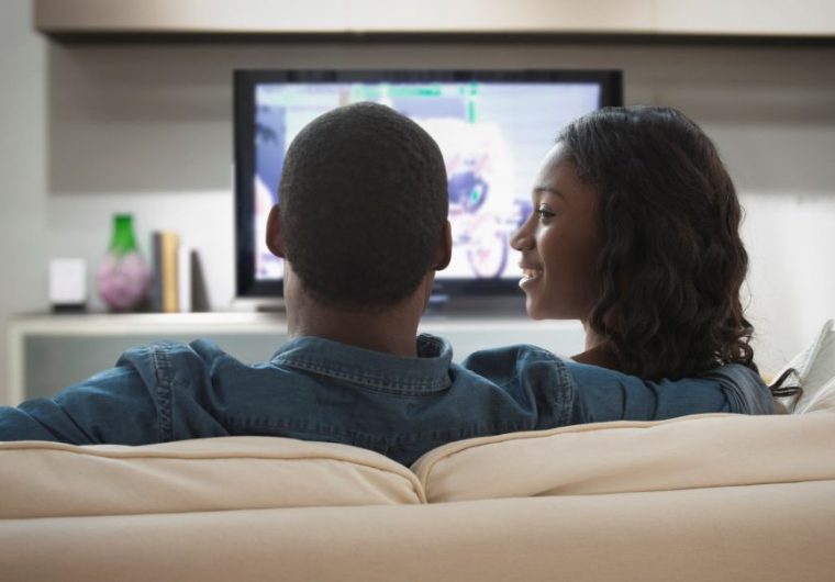 couple using directv programmed remote