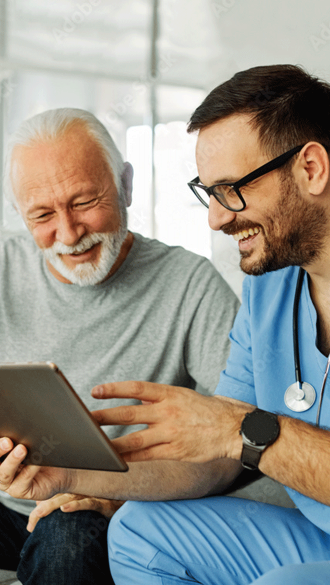 doctor-laughing-with-senior-looking-at-tablet