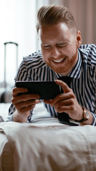 man-on-phone-on-bed-in-hotel