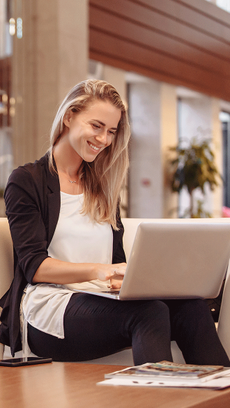 Woman Using Laptop in Hotel Lobby thanks to robust Structured Cabling